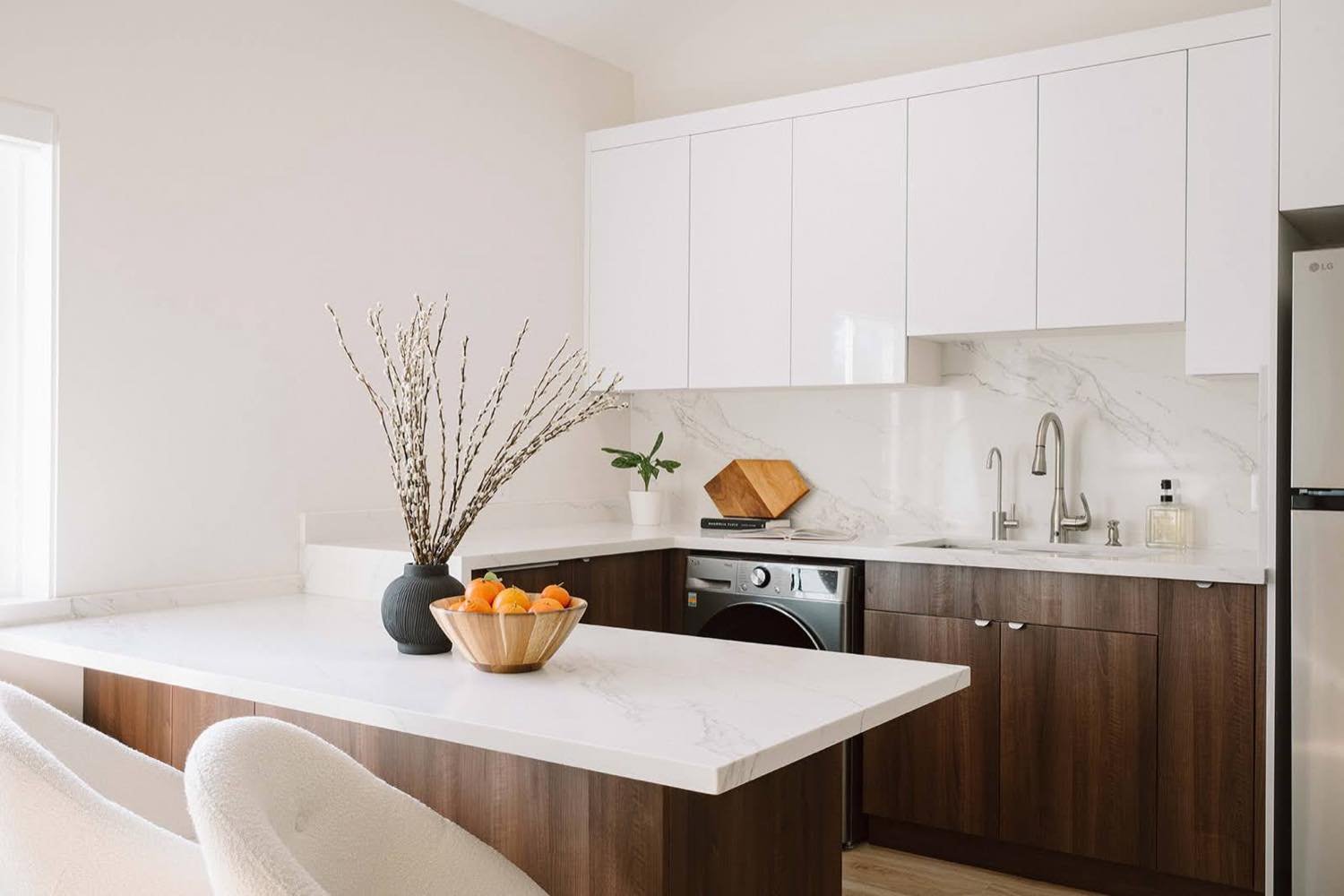 ADU kitchen with waterfall marble island and walnut cabinets